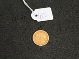 a close up of a coin on a black surface with a price tag