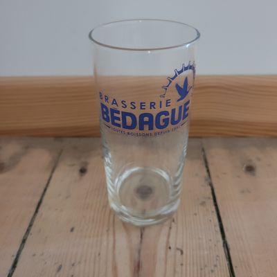 a glass of beer sitting on a wooden table