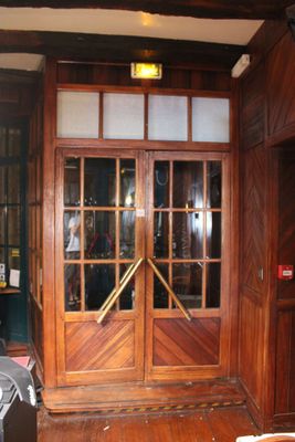 une grande porte en bois qui donne sur un salon