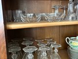 de nombreux verres et assiettes rangés sur une étagère dans un placard