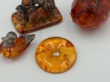 three pieces of amber and silver jewelry on a white surface