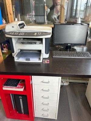 a computer desk with a printer and a monitor on it