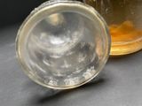 a glass jar with a liquid inside of it on a table