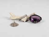 a close up of a small piece of jewelry on a white surface