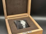 a close up of a wooden box with a watch inside of it