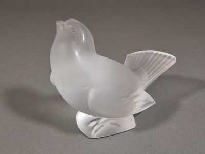 un oiseau en verre posé sur une table