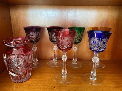 Plusieurs verres à vin sont alignés sur une étagère dans un placard