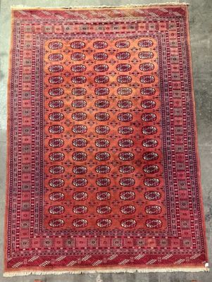 a red and orange rug on a concrete floor