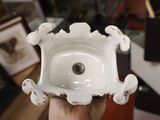 a person holding a small white bowl in their hand
