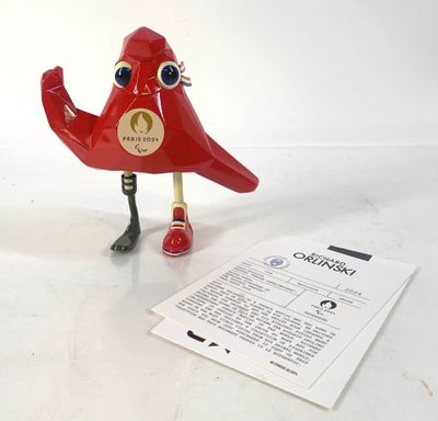 un oiseau rouge posé à côté d'une feuille de papier