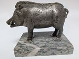 a statue of a boar standing on a marble base