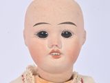 a small doll that is sitting on a white surface