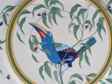 a plate with a bird painted on it on a table