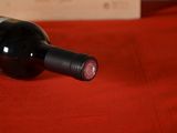 a bottle of wine sitting on a red table cloth