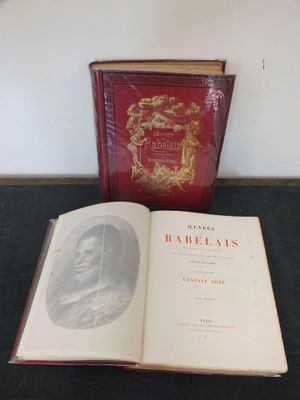 un livre ouvert posé sur une table, à côté d'un livre rouge