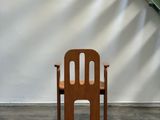 a wooden chair sitting in front of a white wall