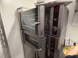 a man standing in front of an oven in a kitchen