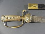 a sword with a gold handle on a table