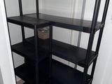 une étagère noire dans un coin d'une pièce