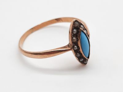 gros plan d'une bague en or avec une pierre bleue