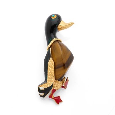 a black and gold duck brooch on a white background