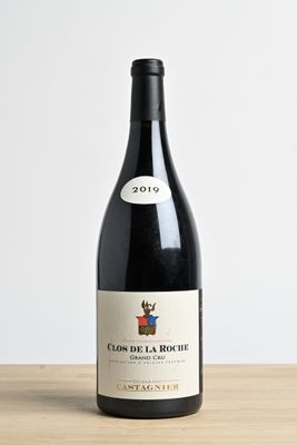 the bottle of wine is sitting on a wooden table