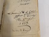 an old book with writing on it sitting on top of a table