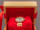 une photo d'une montre en or dans un coffret rouge, avec une cravate rouge