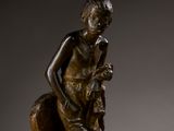 bronze statue of a boy with a dog on a rock