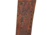 an old wooden skateboard that is leaning up against a white wall