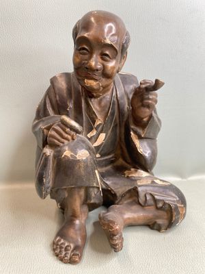 une statue en bronze d'un homme assis sur un rocher