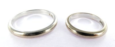 two silver rings sitting on top of each other on a white surface