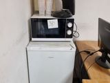 un micro-ondes et un petit réfrigérateur dans un coin de la pièce