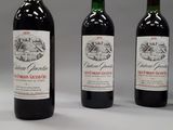 three bottles of wine are lined up on a white surface