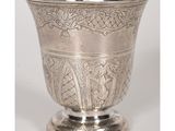 une image représentant une coupe en argent posée sur un socle et ornée d'un motif
