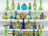 de nombreux vases en verre de différentes couleurs posés sur une étagère blanche