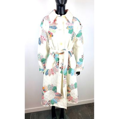 une image représentant un mannequin vêtu d'une blouse blanche ornée de fleurs colorées