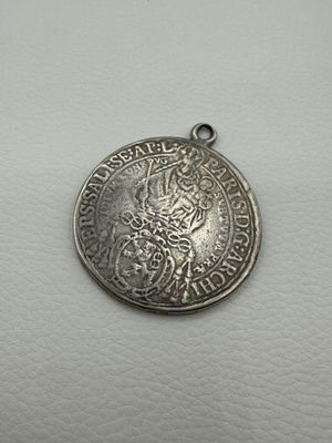 a silver coin with a lion on it sitting on top of a white surface