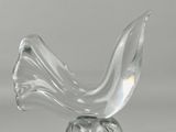 une sculpture en verre représentant un oiseau posé sur un socle