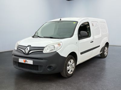 La camionnette blanche est garée dans une pièce au sol noir.