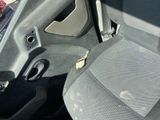 a dirty seat in the car with a broken arm rest