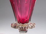 pink glass vase with a flower shaped base on a white surface