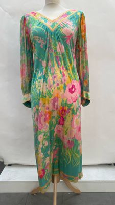 a dress on a mannequin stand in front of a white backdrop