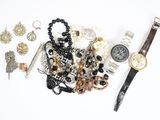a watch, bracelets, and other jewelry laid out on a white surface
