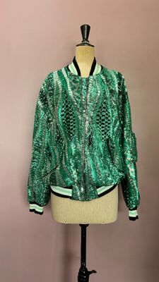 une veste verte à paillettes sur un mannequin, un mannequin, un mannequin, un mannequin, un mannequin, un mannequin, un mannequin, un mannequin