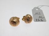 une paire de boucles d'oreilles en or avec une étiquette de prix posée sur un fond blanc