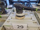une ponceuse posée sur une caisse