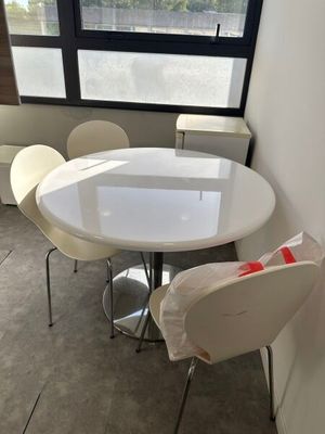 a white table and chairs in a room with a large window