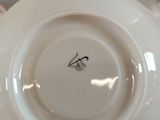 a person holding a white plate with a black bird on it