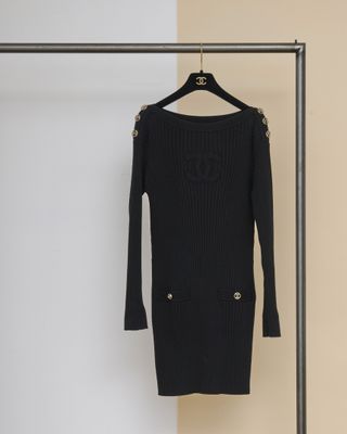 une robe-pull noire suspendue à un cintre dans une pièce